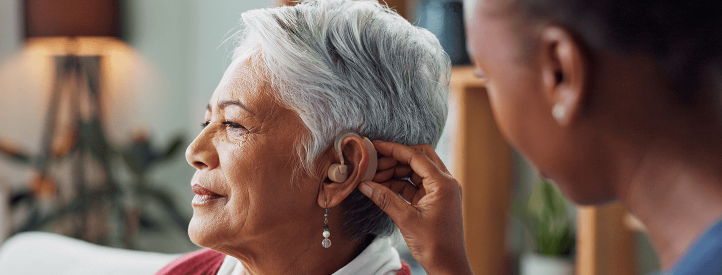 Older woman getting fitted with a hearing aid