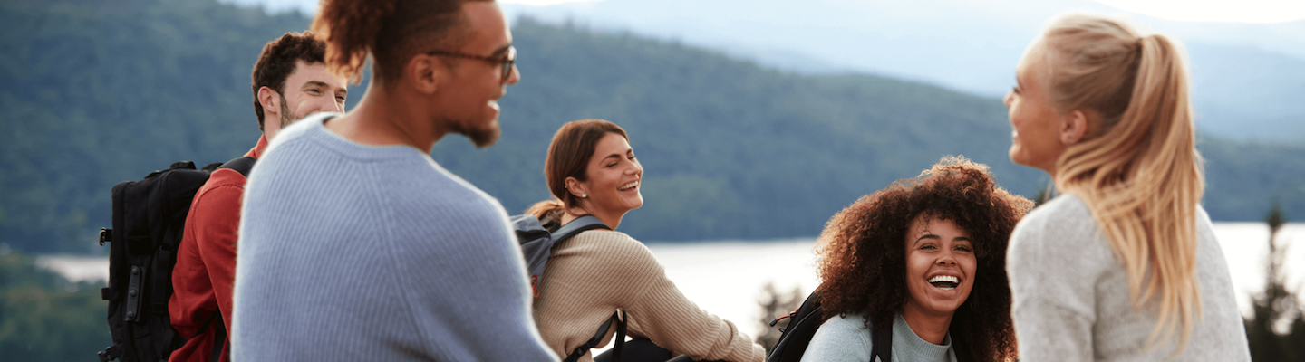 smiling group of diverse people hiking in the mountains